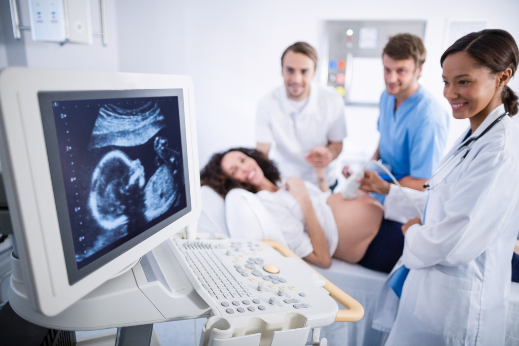 Doctor doing ultrasound scan for pregnant woman in hospital